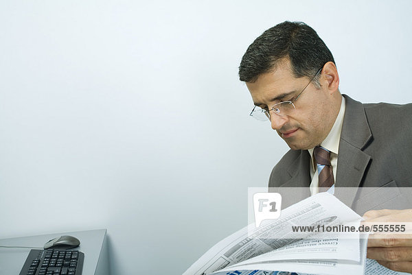 Businessman looking at newspaper