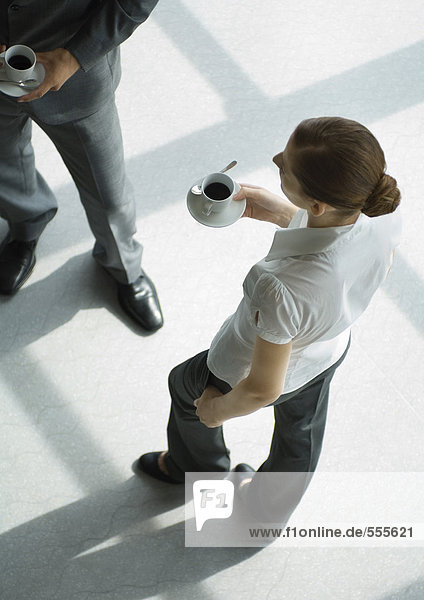 Büroangestellte stehend mit Kaffeetassen  hohe Blickwinkel