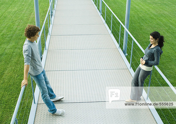 Teenage couple standing face to face on walkway  full length  high angle view