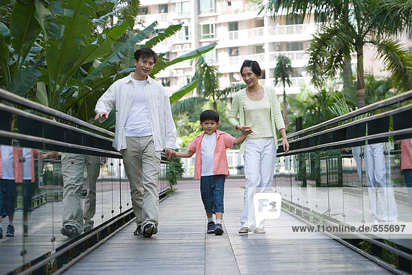 Family walking on bridge together