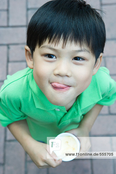 Junge isst Eiscreme,  leckt die Lippen.