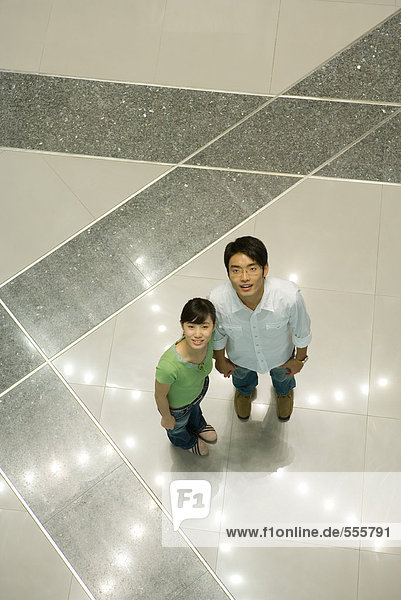 Paar auf sternförmigem Lichtmuster auf dem Boden stehend  hohe Blickwinkel