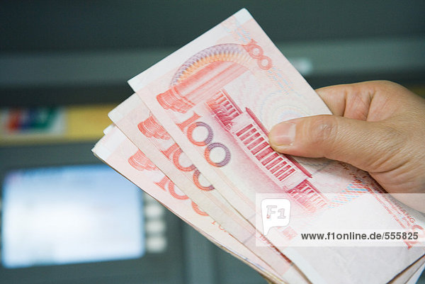 Hand hält 100 Yuan-Scheine