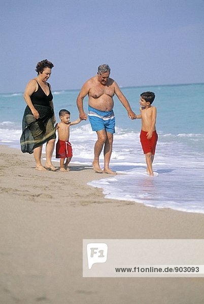 reifes Paar mit Enkelkindern zu Fuß an der Strand  Florida  USA