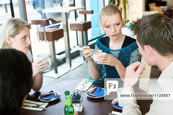 Gruppe von Jugendlichen,  mit einem Chat in einem café