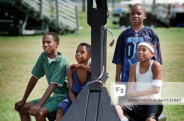 Vier 12 Jahre alten schwarzen Jugendlichen Wait biegen Sie Basketball spielen