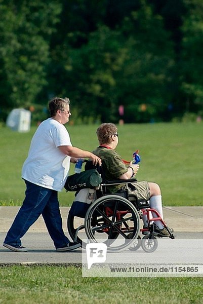 Behinderte Erwachsene fahren im Rollstuhl batteriebetriebene während des Besuchs einer festival