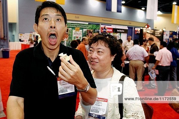 Convention Center,  Americas Food and Beverage Show,  Asian Man reagiert,  hot Sauce,  Uhren Frau. Miami Beach. Florida. USA.
