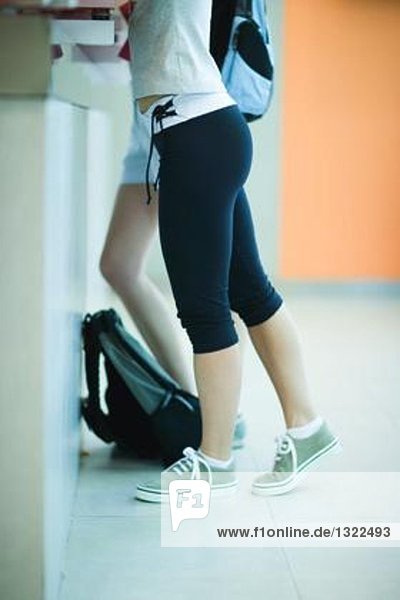 Junge Frau beim Einchecken im Fitnessstudio  Brust unten