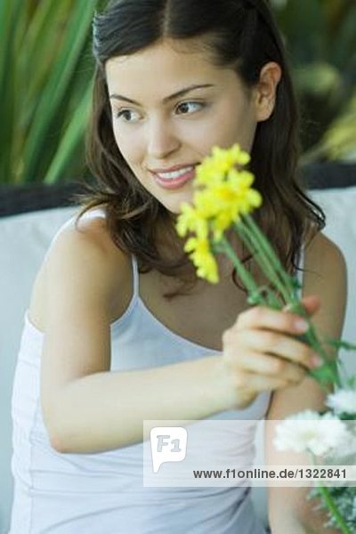 Junge Frau macht frisches Blumenarrangement