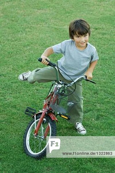Junge auf dem Fahrrad  auf Rasen  hohe Blickwinkel  volle Länge