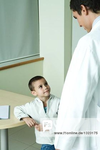 Boy looking up at doctor in doctor's office