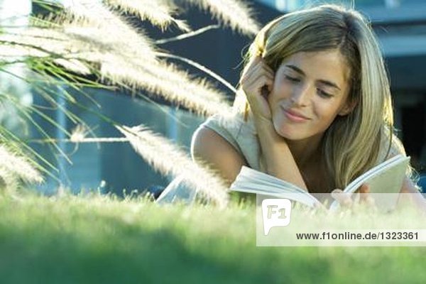 Junge Frau im Gras liegend  Lesebuch