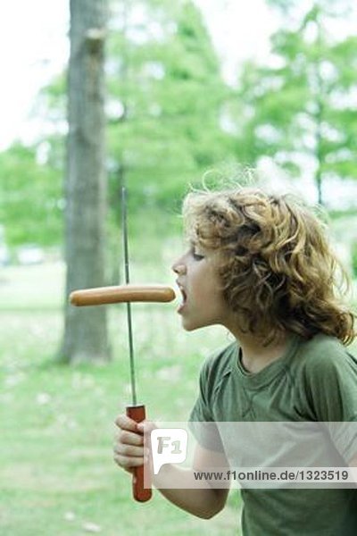 Junge isst Hotdog