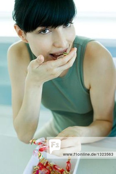 Junge Frau isst Süßigkeiten