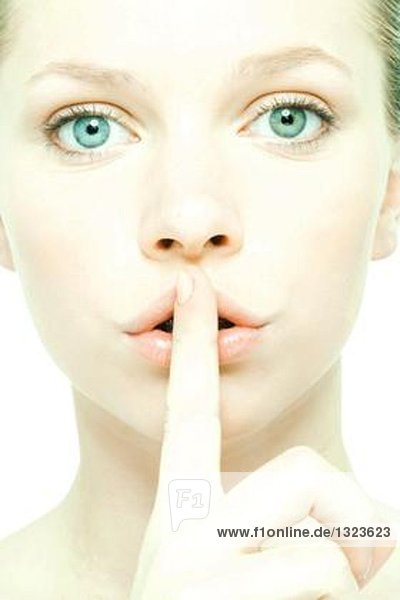 Teenagermädchen hält Finger über die Lippen  Nahaufnahme  Frontansicht  Mund
