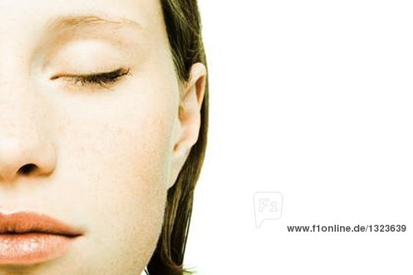 Teenagermädchen,  Auge geschlossen,  abgeschnittene Vorderansicht des Gesichtes