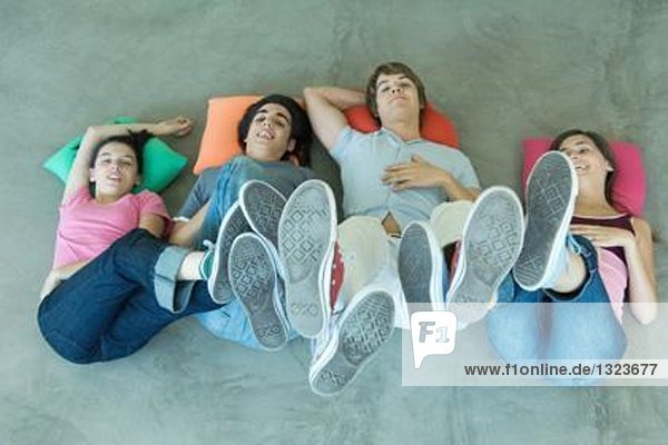 Teenager-Freunde auf dem Boden liegend mit Füßen in der Luft  Blick von oben