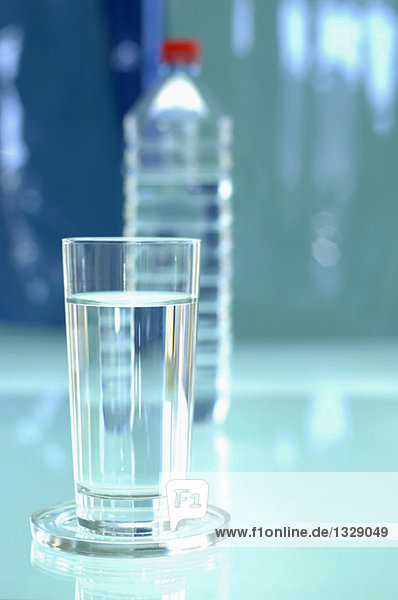 Glas und Flasche mit Wasser gefüllt  Nahaufnahme