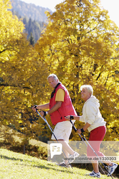 Seniorenpaar Nordic Walking  lächelnd  Seitenansicht