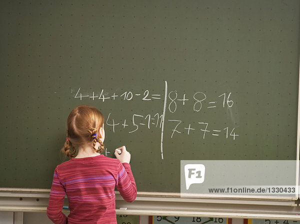 Girl (4-7) schreibt auf Tafel  Rückansicht