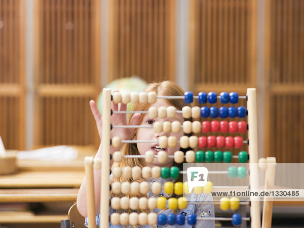 Girl (4-7) using abacus  close-up