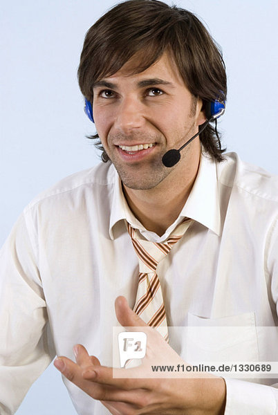 Businessman wearing headset  smiling  close-up