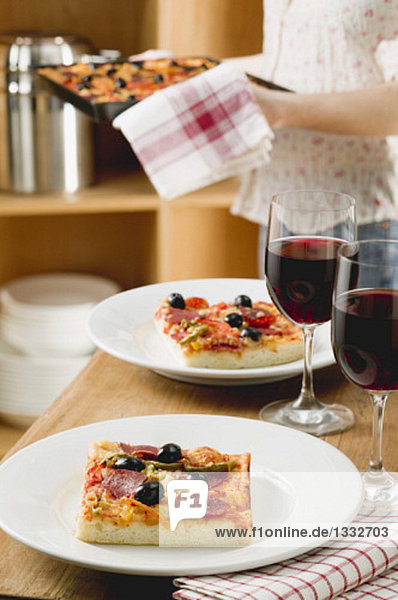 Pizza and red wine for two on table