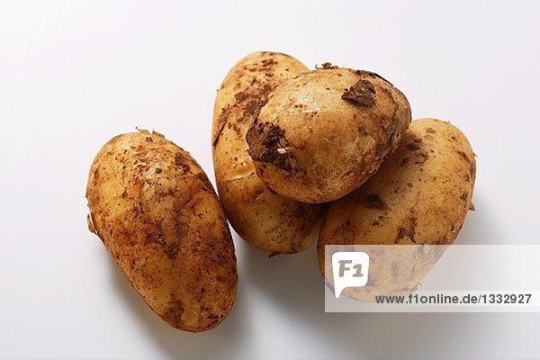 Vier Kartoffeln mit Erde