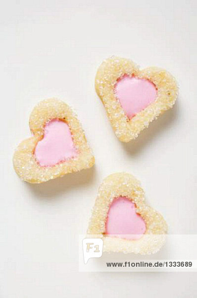 Drei herzförmige Plätzchen mit rosa Glasur