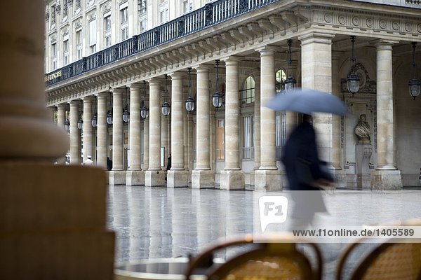Blurred motion view of person walking holding umbrella in city  Paris  France