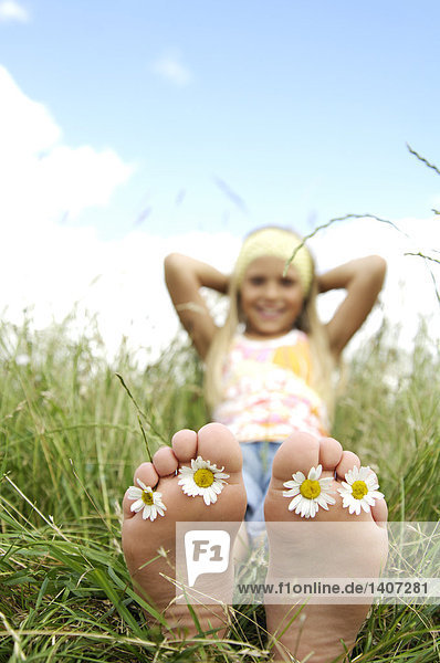 Mädchen mit Blumen in ihren Füßen