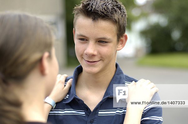 Close-up of teenage boy looking at his friend and smiling