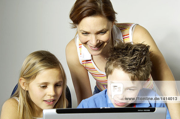 Nahaufnahme Frau betrachten ihre beiden Kinder mit laptop