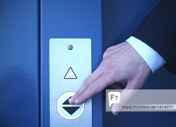 Close-up of businessman's hand pressing elevator's button