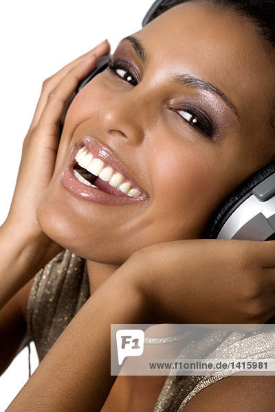 Porträt einer jungen lächelnden Frau  Musik hören mit Kopfhörer