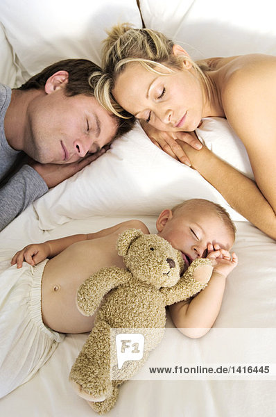 Young couple and baby sleeping  indoors