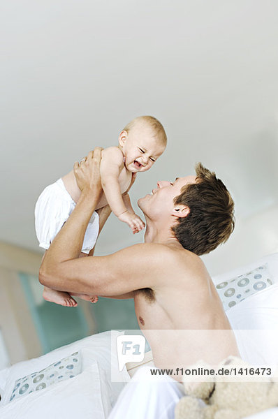 Father lifting his baby  crying  indoors