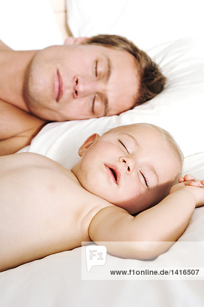 Portrait father and baby sleeping  indoors