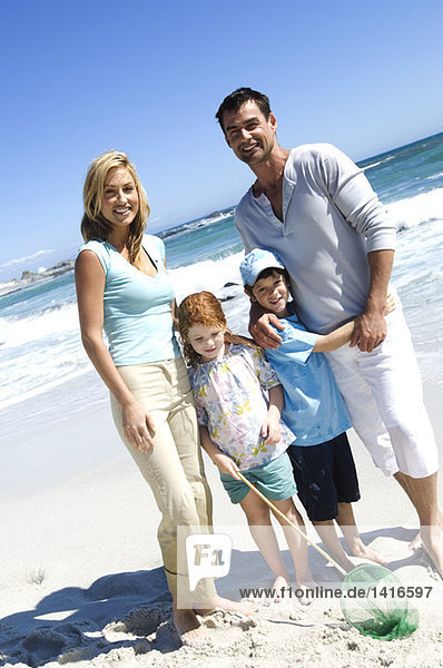 Parents and two children on the beach  posing for the camera  outdoors
