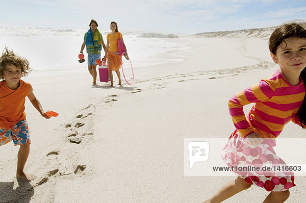 Parents et two children walking on the beach  outdoors