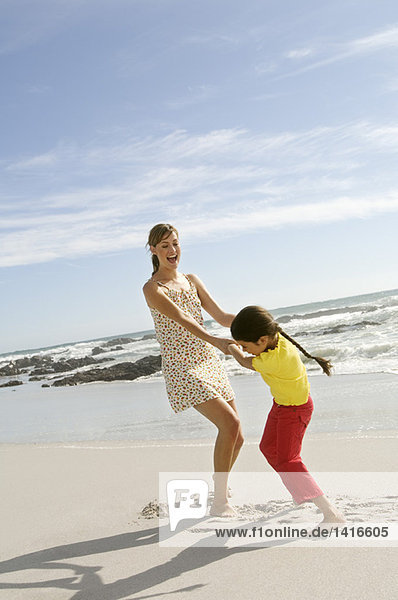 Mother and daughter playing on the beach  outdoors