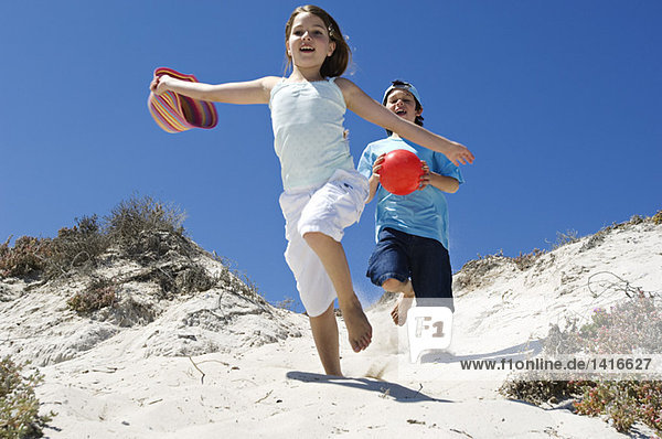 Two children running on the beach  outdoors