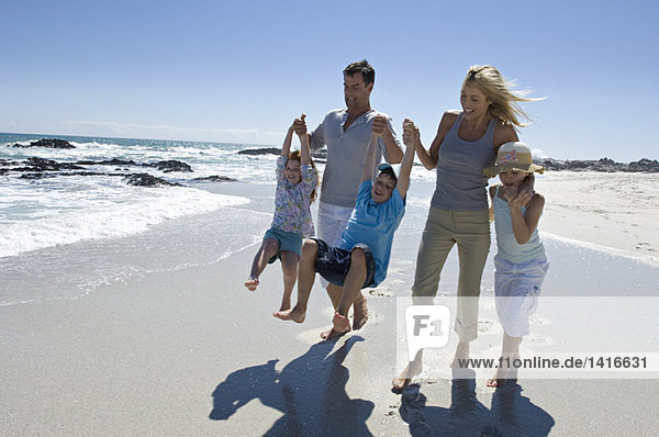 Parents and three children walking on the beach  outdoors