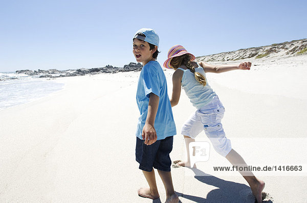 Brother and sister walking on the beach  outdoors