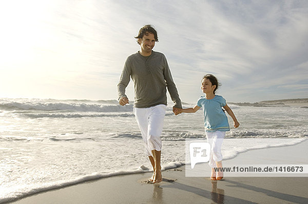 Vater und Tochter beim Spaziergang am Strand  im Freien