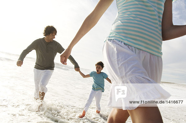 Couple and daughter walking in the sea  outdoors