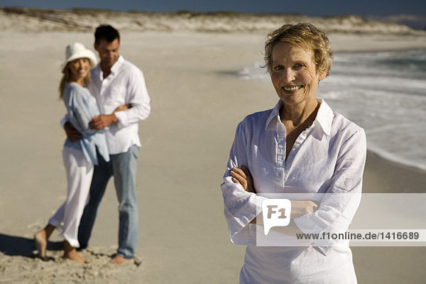 Paar umarmende und ältere Frau am Strand