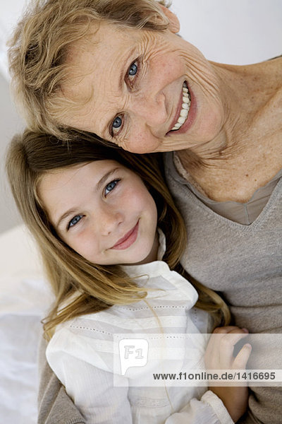 Senior woman and little girl smiling for the camera  indoors
