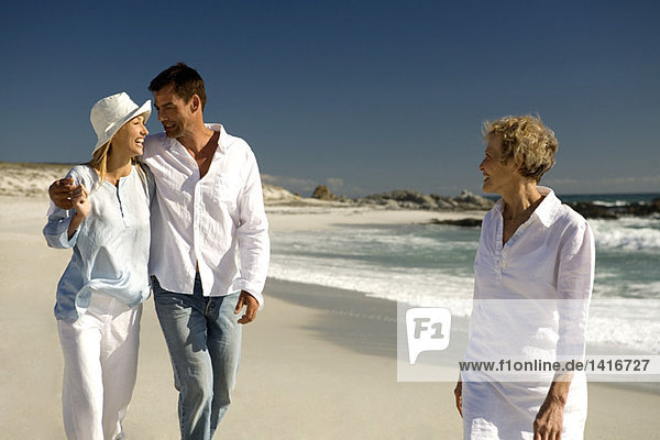 Paar umarmend und Seniorin am Strand aufwachend